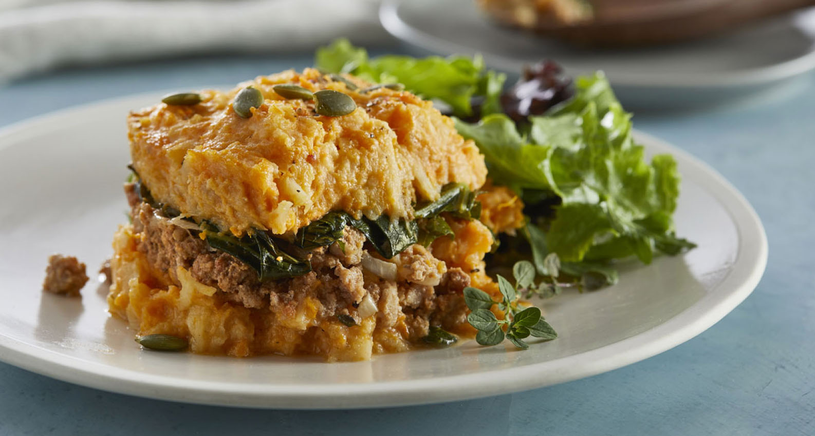 A plate of sweet potato casserole with a salad